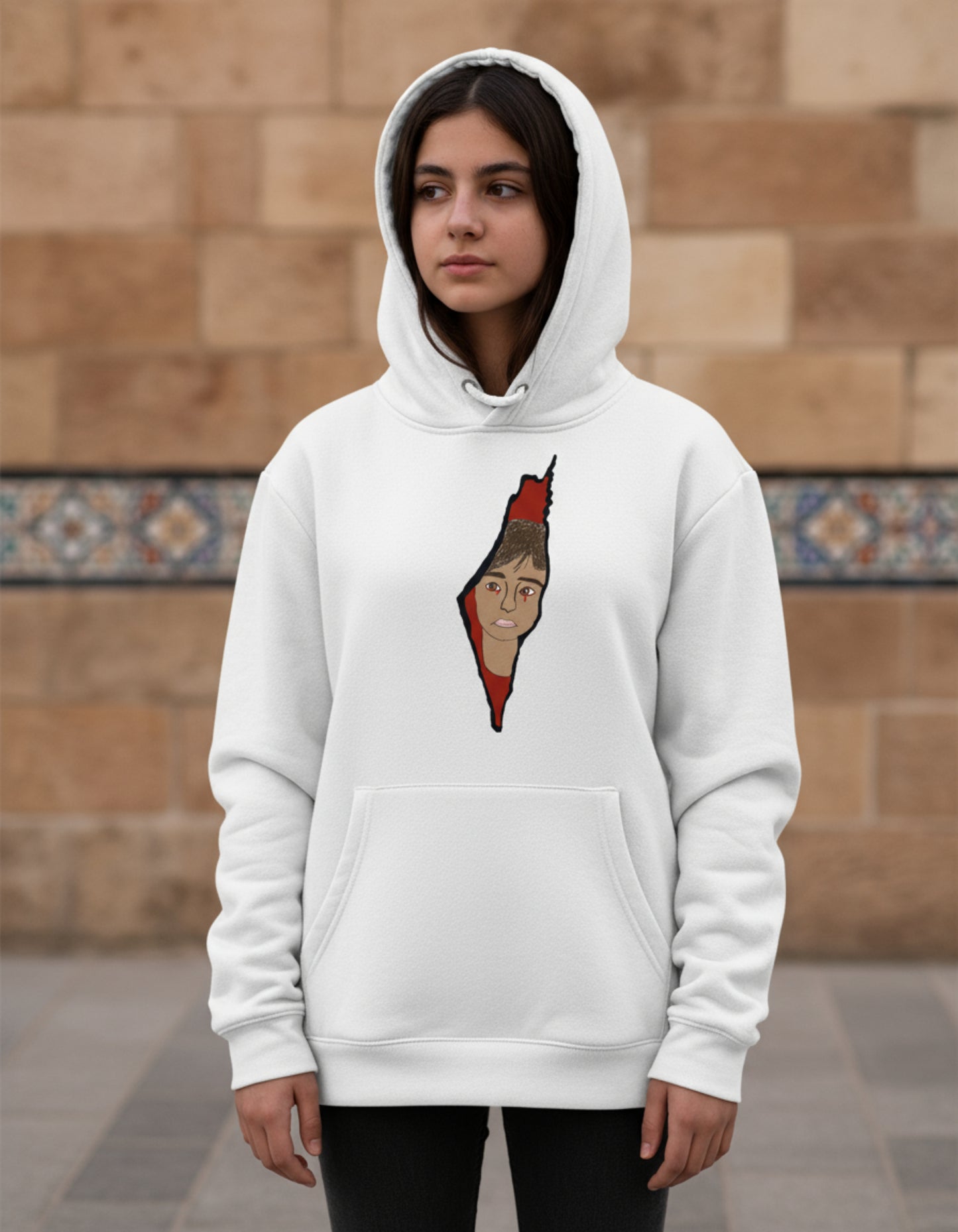 Young girl wearing a hoodie featuring Saja’s hand-drawn outline of Palestine with a portrait design