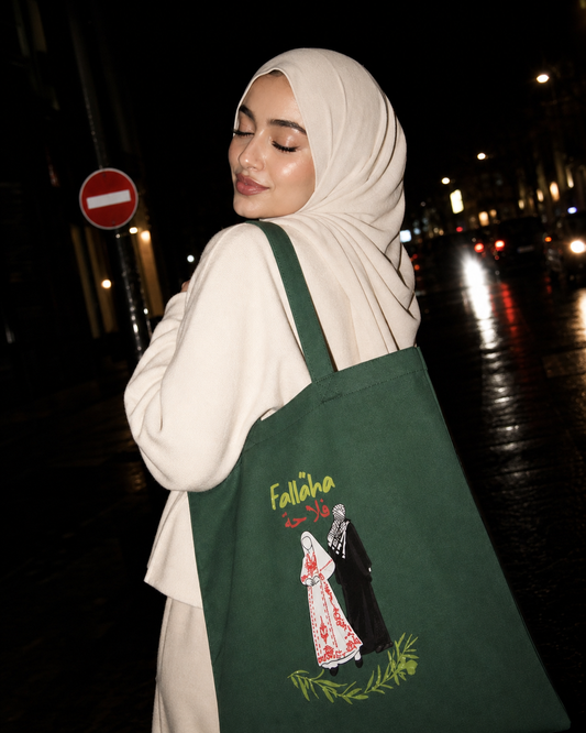 Falaha Palestine cotton tote bag with Palestinian farmer illustration and Arabic text representing heritage and resilience by Warrior Ink Apparel