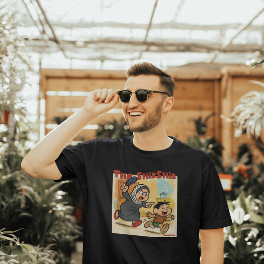 A male model wears Black organic t-shirt featuring retro-style Arab cartoon of a mother chasing her son with a shibshib (slipper), text reads ‘The ShibShib’.
