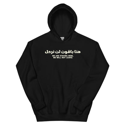 Black hoodie with Arabic and English text on the front reading “We are staying here, we will not leave”